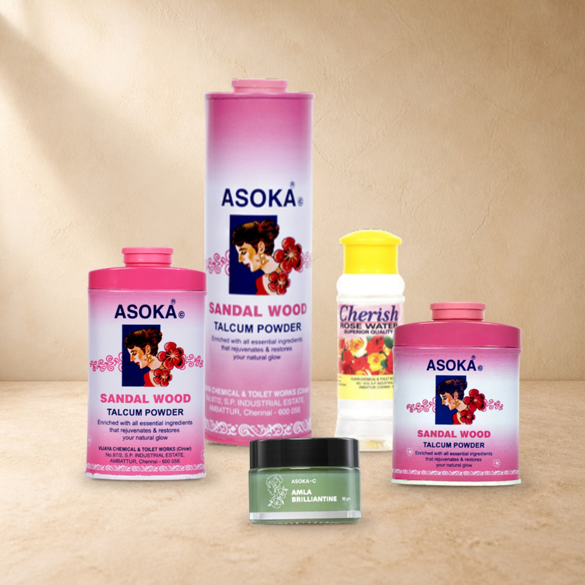 Asoka Ritual Set – Pink: Pink Sandalwood Talcum Powder 300g, 70g and 35g with Amla Brilliantine 30g and Cherish Rosewater 100ml, arranged on a sandstone tabletop